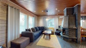 a living room with a blue couch and a fireplace at Holiday Cabin Villa Kalle in Himos +23 photos