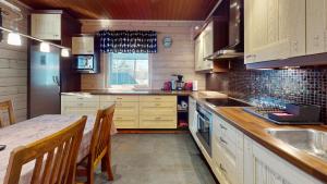 a kitchen with wooden cabinets and a counter top at Holiday Cabin Villa Kalle in Himos