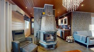 a living room with a fireplace and a couch at Holiday Cabin Villa Kalle in Himos