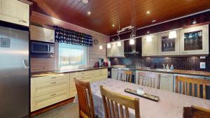a kitchen with a table with chairs and a refrigerator at Holiday Cabin Villa Kalle in Himos