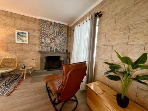 Una sala de estar con una silla y una chimenea. en Vila Mandala, en Ponta Delgada