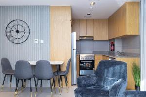 a kitchen with chairs and a table and a clock at The Cloud 9 Penthouse by Blue Cloud Holidays in Sharjah Intl