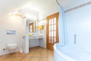 a bathroom with a tub and a toilet and a sink at Chalet Sonnenhang Oberhof in Oberhof +47 photos