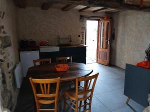 a kitchen with a wooden table and four chairs at gîte les 3 coquelicots bis in Coublanc