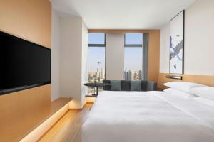 杭州市にあるFairfield by Marriott Hangzhou Gongshuの大きなベッドと薄型テレビがあるホテルの部屋