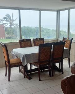 a dining room with a table and chairs and a window at Afsaal 205 in Amanzimtoti