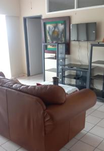 a brown leather couch sitting in a living room at Afsaal 205 in Amanzimtoti