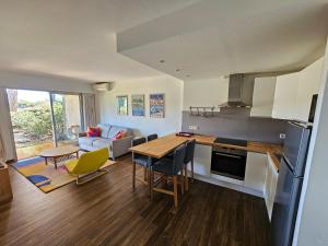 a kitchen and living room with a table and chairs at Appartement golf de Valescure avec jardin in Saint-Raphaël