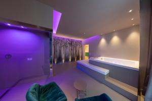 ナポリにあるSmart Hotel Napoliの紫色の照明が付いたバスルーム(バスタブ付)
