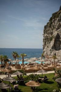 a resort with tables and umbrellas next to the ocean at Hotel Vista di Capri in Massa Lubrense