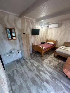 a small room with a bed and a tv at Apartmani Mila , Nova drvena kucica in Vrdnik