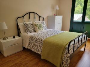 a bedroom with a bed with a black and white bedspread at Belmonte in Belmonte de Miranda +23 photos