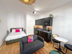 トゥールーズにあるLe Drapier - Centre - Luxe - Chaletsのベッドとソファとテーブルのある寝室