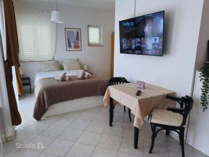 a bedroom with a bed and a table and a tv at Apartments ALI & EL - perfect for couples in Rovinj