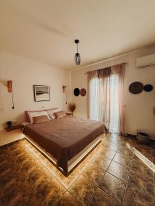 a bedroom with a large bed and a window at Naxian Sofias garden in Naxos Chora