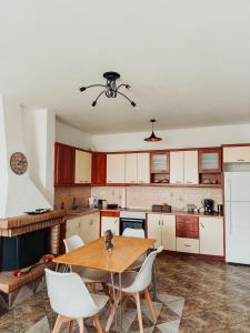 a kitchen with a wooden table and white cabinets at Naxian Sofias garden in Naxos Chora +36 photos