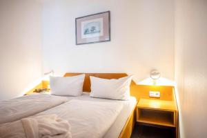 a bedroom with a bed with two white pillows at Inselresidenz Strandburg 104 in Juist