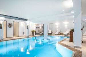 a pool in a hotel with white walls and blue water at Inselresidenz Strandburg 104 in Juist