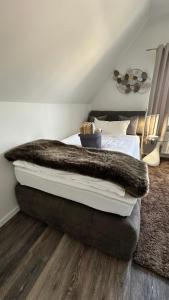 a bedroom with a bed with a faux fur blanket at HARMONY "2" stylishes 2 Zimmer Apartment 1 OG Balkon Garten Parkplatz in Gütersloh