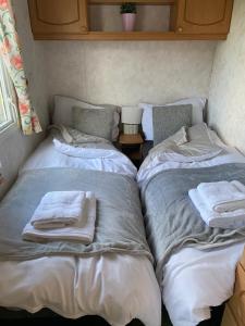 two beds in a small room with towels on them at Craigmore Caravan in Coleraine