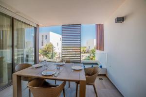 a dining room with a table and chairs and a large window at Santorini - Luxury Seaside Apartment in Taghazout