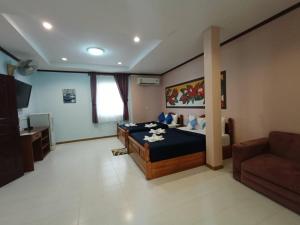 a large bedroom with a bed and a couch at โรงแรมอิ่มสุข บางสะพาน in Sathani Bang Saphan Yai