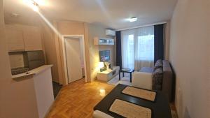 una pequeña sala de estar con sofá y ventana en Riverside rest, en Niš