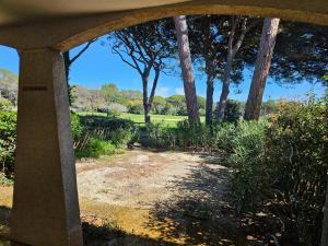 a view of a garden from under a porch at Appartement golf de Valescure avec jardin in Saint-Raphaël +3 photos