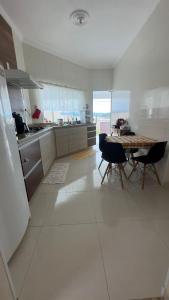 een grote witte keuken met een tafel en stoelen bij Parque das águas in Guapé