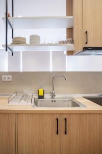 a kitchen with a stainless steel sink and cabinets at Urban Athens Gem in Athens