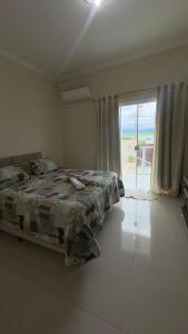 een slaapkamer met een bed en uitzicht op de oceaan bij Parque das águas in Guapé
