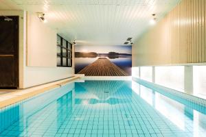 ein Schwimmbad mit einem Wandgemälde eines Docks in der Unterkunft Finlandia Park Hotel Helsinki in Helsinki