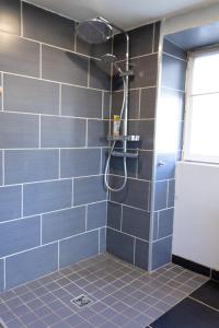 a bathroom with a shower with blue tiles at Ty Grégoire - Campagne - Wi-Fi in Crozon