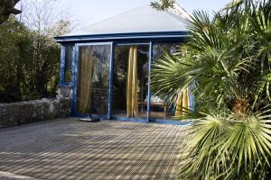 a house with glass doors and a palm tree at Ty Grégoire - Campagne - Wi-Fi in Crozon +14 photos