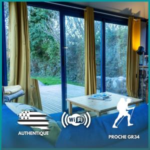 a living room with a table and a large window at Ty Grégoire - Campagne - Wi-Fi in Crozon