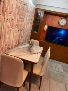 a dining room with a table and chairs and a tv at South-East-West Facing 3 BHK Lakeview Flat Howrah West Bengal in Hāora