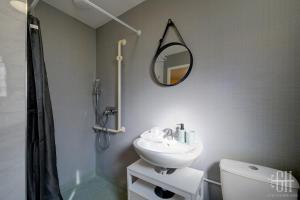 ein Badezimmer mit Waschbecken und Spiegel in der Unterkunft Mercure - Proche A10 -2 V -Parking- Rez-de-chaussée in Saint-Pierre-des-Corps