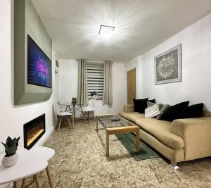 ein Wohnzimmer mit Couch und Kamin in der Unterkunft Fabulous Fiery Flat W Body Shower - Tylorstown in Llwyn-y-pia