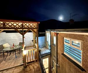 Blick auf eine Terrasse mit einem Tisch und einem Mond in der Unterkunft Fabulous Fiery Flat W Body Shower - Tylorstown in Llwyn-y-pia