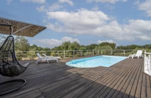 a deck with a hammock and a swimming pool at Casale dello Zio, private pool by IL PUMO DI PUGLIA in Castellana Grotte