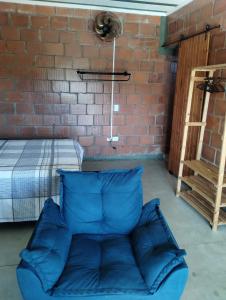 un divano blu in una stanza con un muro di mattoni di Bangalô Alto da Pedreira a Socorro