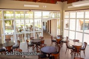 a restaurant with tables and chairs and windows at Porto Marina Resort in Ilha Comprida