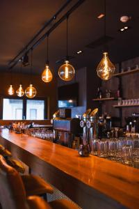 eine Bar in einem Restaurant mit Gläsern und Lichtern in der Unterkunft Herz3 Hotel Bar Restaurant Trattoria in Hollersbach im Pinzgau + 42 Fotos