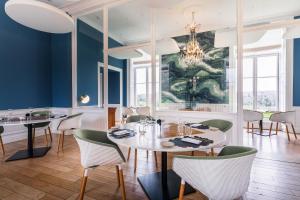 a dining room with blue walls and a table and chairs at Château de Boisgelin - Hôtel & Restaurant Mathieu Kergourlay in Pléhédel