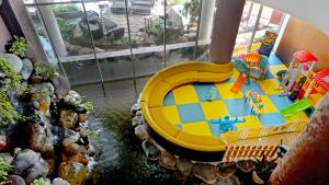 a toy house with a yellow slide in a room at Grand Soll Marina Hotel in Tangerang +47 photos