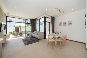 un salon avec une table et un canapé dans l'établissement Goldena Twin Project - 3 Bedrooms Pool Villa, à Kamala Beach