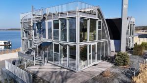 a glass house with a spiral staircase in front at Open-Water-Resort in Geierswalde