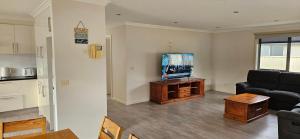 a living room with a couch and a flat screen tv at Penguin Retreat in Penguin