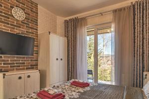 a bedroom with a bed with a tv on a brick wall at FAVAR Carpathians in Skhidnitsa