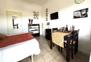 a bedroom with a bed and a table and a bed and a desk at Studio Bohème à St Florent Grande terrasse in Saint-Florent